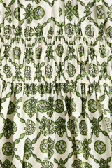 Vestido corto de algodón con estampado geométrico en tonos verdes y blancos. Cuenta con escote en V, mangas globo con elástico en los puños, cuerpo fruncido tipo nido de abeja en la cintura y falda con vuelo.
