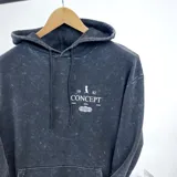 Canguro negro oversize con efecto lavado y estampado en la espalda con la palabra "Concept" y otros textos en blanco.