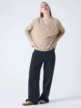 Suéter poncho de mujer, color gris claro, tejido en cashmere, con cuello en V, mangas largas acanaladas y aberturas laterales.