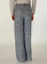 Pantalon de corte recto y tiro medio, confeccionado en tejido con textura jaspeada en tonos grises y azules, con ruedo desflecado.