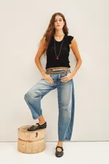 Musculosa de tejido de punto de algodón, con diseño ajustado al cuerpo, cuello redondo y detalle de volados en los hombros.