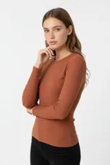 Remera de manga larga confeccionada en tejido de punto canalé, con ajuste al cuerpo y cuello redondo.