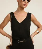 Blusa sin mangas de tejido tipo airflow, con escote en V y breteles anchos. Presenta una textura ligeramente arrugada y costura central vertical decorativa.