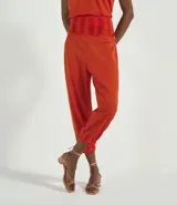Pantalón jogger color naranja, con cintura alta elástica y terminación ajustada con elástico en los tobillos.