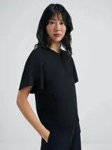 Blusa color violeta con mangas cortas evasé y cuello redondo.