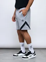 Bermuda deportiva negra de algodón y poliéster, con cintura elástica ajustable con cordón, bolsillos laterales y detalle de recortes geométricos en gris en los laterales. Logo de la marca bordado en la pierna izquierda.