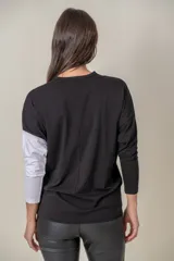 Remera negra de algodón con una manga larga blanca y corte holgado.