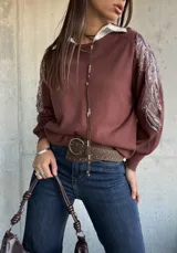 Sweater de punto color chocolate con cuello redondo y mangas largas abullonadas. Presenta detalles bordados con lentejuelas brillantes en los hombros y parte superior de las mangas.