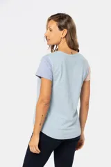 Remera de manga corta con cuello redondo y diseño de bloques de color. El cuerpo es beige, la manga izquierda es azul claro y la manga derecha es rosada.