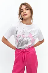 Remera blanca de algodón con estampado de flor en tonos grises y rosados.