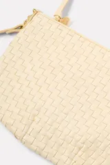 Bandolera color crema, tejida a mano, con correa al hombro de cuero color beige y cierre superior con cremallera.