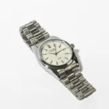 Reloj de pulsera plateado con esfera blanca, agujas negras y correa de eslabones metálicos.