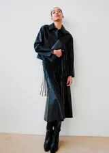 Chaqueta de cuero sintético color negro, con cuello camisero, cierre frontal oculto y mangas largas con puños rectos.