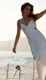 Vestido largo blanco con breteles finos, escote drapeado y aberturas laterales en la cintura.