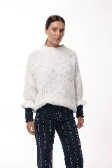 Sweater de tejido de punto con silueta relajada, cuello redondo y mangas 3/4 abullonadas con puños ajustados que aportan volumen.