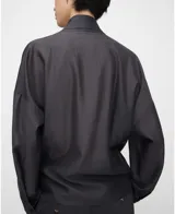 Blusa gris de corte cruzado tipo cache-coeur, con escote en V, mangas largas y detalle de lazo para atar en el lateral de la cintura. Confeccionada en mezcla de liocel y poliéster.