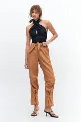 Pantalón de lino color marrón claro, con corte recto, cintura alta con lazo ajustable, elástico en la parte trasera y presillas en las piernas.