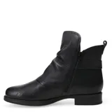 Botas de cuero negro con interior forrado en corderito sintético color crema. Presentan caña media con solapa superior, detalle de tira lateral con hebilla metálica y cierre lateral interno.