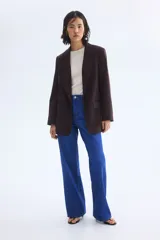 Blazer de sarga color bordó con solapas de pico, frente abierto y bolsillos delanteros ribeteados con solapa.