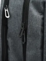 Mochila gris con cierre superior y bolsillo frontal con cierre. Tiene dos bolsillos laterales de red y logo de la marca en blanco en la parte superior.