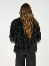 Chaqueta de textura peluda con flecos, de corte recto y manga larga, ideal para un look texturizado.