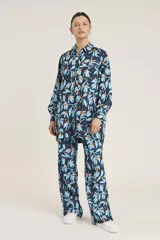 Camisa de manga larga con cuello clásico y estampado de hojas y flores en tonos azul y naranja sobre fondo azul marino.