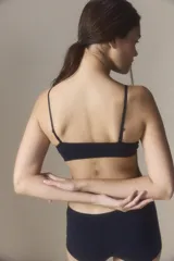 Top de estilo deportivo confeccionado en tejido seamless, con breteles finos y escote redondeado. Presenta un diseño minimalista y ajustado con el logo de la marca estampado en el bajo busto.