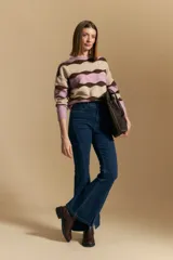 Jean oxford de tiro alto confeccionado en denim con spandex, de color gris oscuro lavado. Presenta un corte ajustado en la parte superior que se ensancha hacia el ruedo, el cual incluye aberturas frontales.