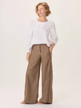 Pantalon de pierna ancha color marron, con detalle de tira lateral a contraste y pespuntes decorativos. Cuenta con cierre frontal y bolsillos laterales.
