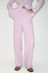 Pantalón de tiro alto color rosado, con pernera recta, bolsillos delanteros y cierre frontal con cremallera, botón interior y gancho.