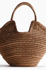 Bolso shopper de doble asa confeccionado en paja de papel trenzada, sin forro y con diseño estructurado.