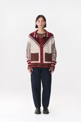 Cardigan de punto con diseño multicolor, cuello tipo polo con rayas, cierre frontal con botones y bolsillos aplicados. Presenta mangas con trama trenzada, coderas en contraste y bordado de la marca en el frente.