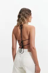 Musculosa de breteles finos con escote en "V" y lazo en la espalda, con lentejuelas sutiles.