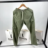 Pantalón cargo verde de nylon, corte holgado con bolsillos laterales y cintura elástica ajustable con cordón.