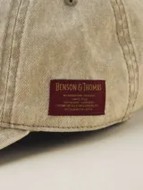 Gorra de béisbol color gris oscuro con efecto lavado o acid wash, visera curva y panel frontal estructurado. Presenta una pequeña etiqueta negra cosida en el lateral trasero.