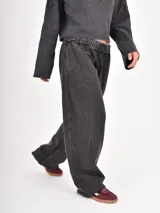 Pantalón de corte holgado con efecto lavado, cintura elástica con cordón ajustable y bolsillos laterales.