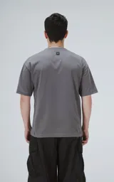 Remera de algodón premium color gris concreto, con corte crop, calce oversize, hombros caídos y cuello redondo rib al tono.