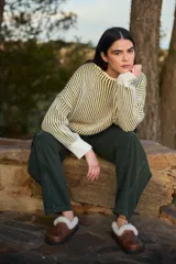 Sweater de punto con diseño de rayas verticales en contraste blanco y negro, cuello redondo y mangas largas con puños ajustados.