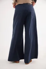 Pantalón de tiro medio con diseño de pierna ancha y cortes curvos que aportan movimiento. Presenta cintura ajustada, bolsillos delanteros y bolsillos plaque en la parte trasera.
