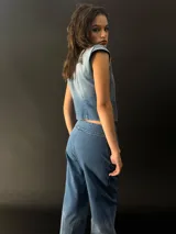 Chaleco de jean con cuello y pequeñas mangas, con alforzas texturizadas en los laterales.