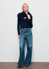 Pantalón de jean estilo wide leg con tiro medio, cierre frontal de cremallera y botón, cinco bolsillos y detalle de tachuelas en la cintura.