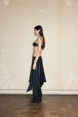 Top bustier negro de cuero ecológico con tirantes finos ajustables y cierre frontal con hebilla metálica.