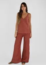 Pantalón palazzo color ladrillo, de tiro alto y corte amplio. Confeccionado en lino.