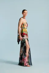Vestido largo strapless de diseño entallado, con estampado floral multicolor sobre base negra, falda con abertura frontal pronunciada y superposición de capas.