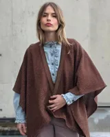 Ruana de punto color marrón con detalles de hilo lurex dorado, diseño abierto y corte amplio.
