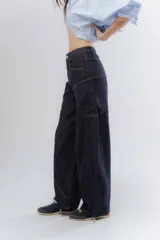 Pantalón jean wide leg de tiro medio, color azul oscuro, con costuras decorativas marcadas y diseño amplio de corte recto.
