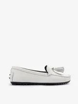 Mocasín plano Bert de punta redondeada, confeccionado en cuero vacuno color blanco con costuras artesanales y detalle de borla de flecos en el empeine, sobre suela de goma.