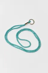Correa para celular o accesorios, confeccionada con una cadena de strass en color turquesa brillante, con terminaciones metálicas y argolla circular plateada.