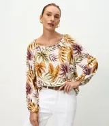 Blusa de viscosa con estampado de follajes en tonos tierra, escote bote y mangas largas abullonadas con puños elásticos.