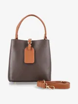 Cartera estructurada color marrón oscuro con asa de mano y correa regulable y desmontable en color marrón claro. Incluye un detalle decorativo de hebilla y etiqueta colgante en la parte frontal.